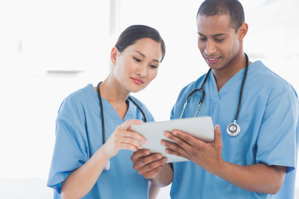 istock Surgeons looking at digital tablet in hospital 832833784