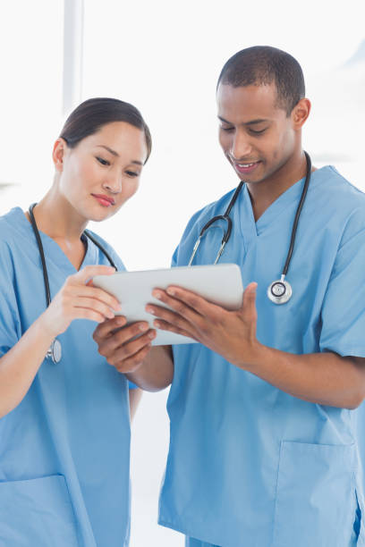 istock Male and female surgeons looking at digital tablet 832833886