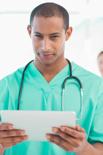 istock Handsome male doctor holding digital tablet 832834262