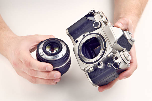 istock Retro photo SLR camera and lens in hands 832865542