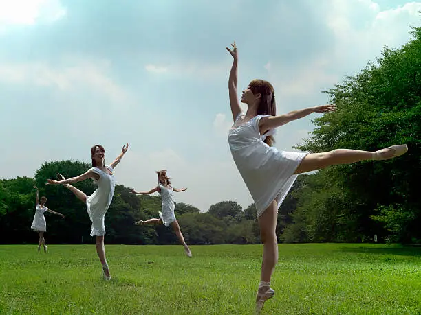 Photo of The plural same people do a ballet dance in a park