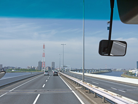 Driving by highway in Tokyo, long overpass over water, Japan