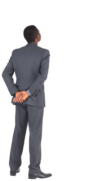 Businessman standing with hands behind back Businessman standing with hands behind back on white background hands behind back stock pictures, royalty-free photos & images