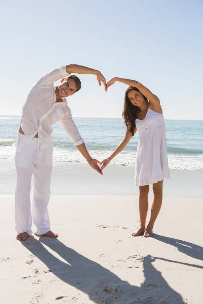 istock Romantic couple forming heart shape with arms 832968088