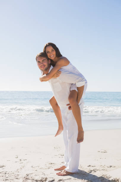 istock Handsome man giving happy girlfriend a piggy back 832968382