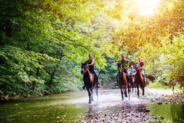 Riders and horses crossing the river