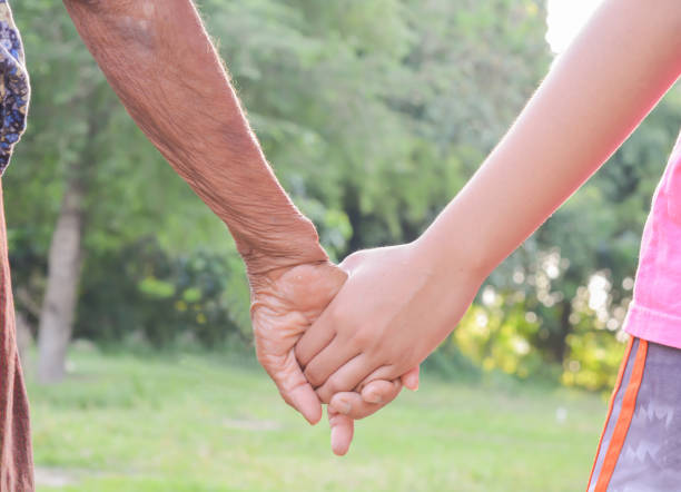 istock Hand,old and children's hand with light of the evening. 832985610