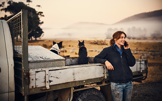 Shot of a young woman using a mobile phone on her farm