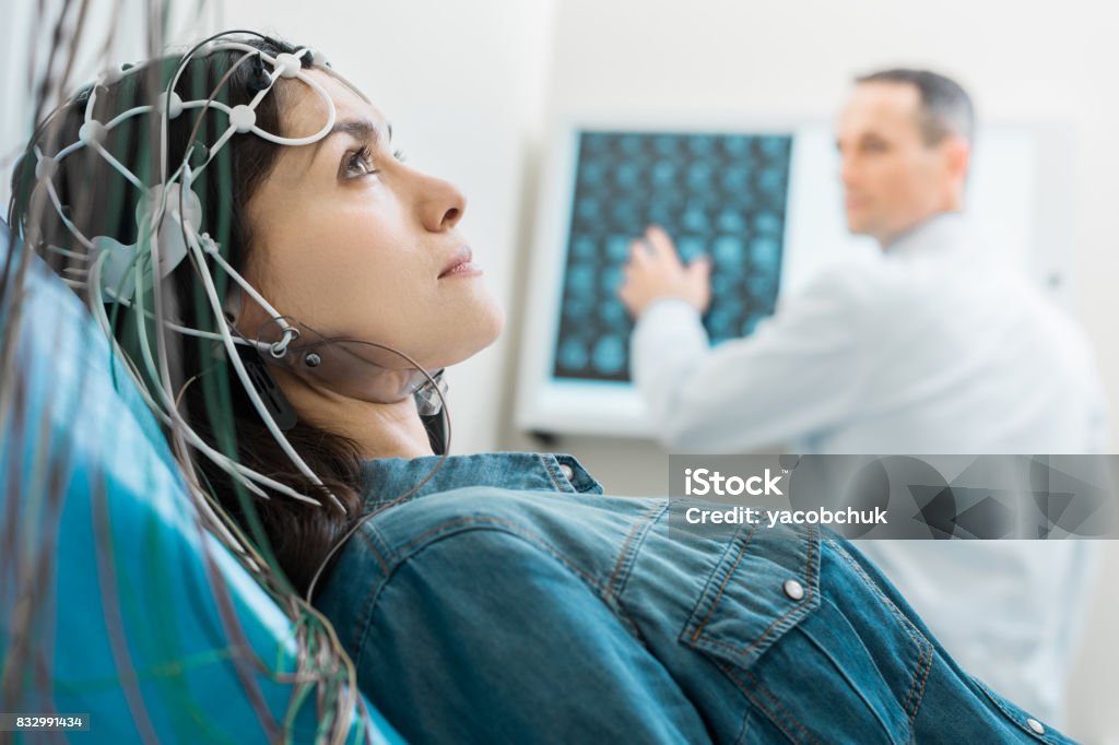 Affascinante giovane donna sottoposta a elettroencefalografia - Foto stock royalty-free di Elettroencefalogramma