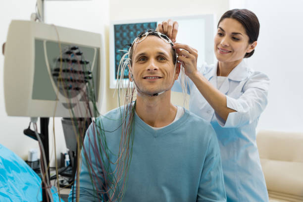 medico donna che rimuove elettrodi dalla testa dei pazienti - eeg foto e immagini stock