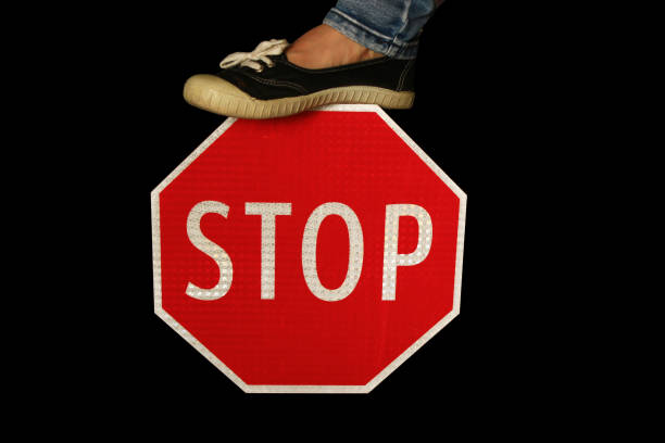 istock Woman's Foot Stepping on a Stop Sign 833007982