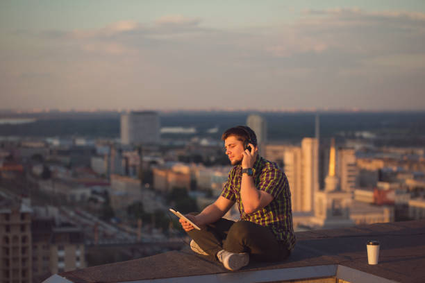 istock Man is listening to music on roof. 833019862