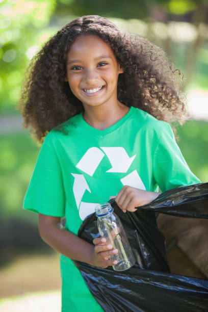 istock Young environmental activist smiling at the camera picking up trash 833034802