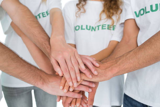 istock Closeup mid section of volunteers with hands together 833035624
