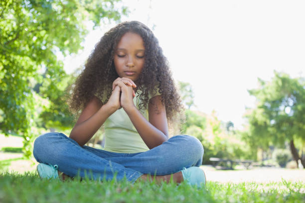 istock Young girl praying in the park 833037962