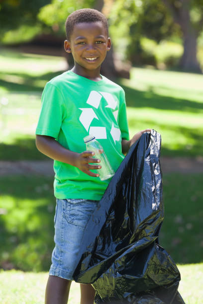 istock Young boy in recycling tshirt picking up trash 833041836