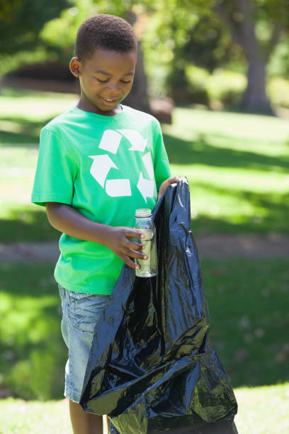 istock Young boy in recycling tshirt picking up trash 833041894