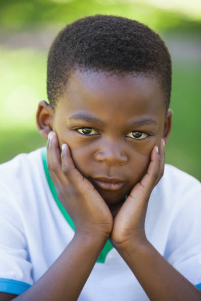 istock Cute boy pouting at the camera in the park 833042180