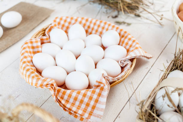 istock Chicken eggs in basket on wooden background 833054346
