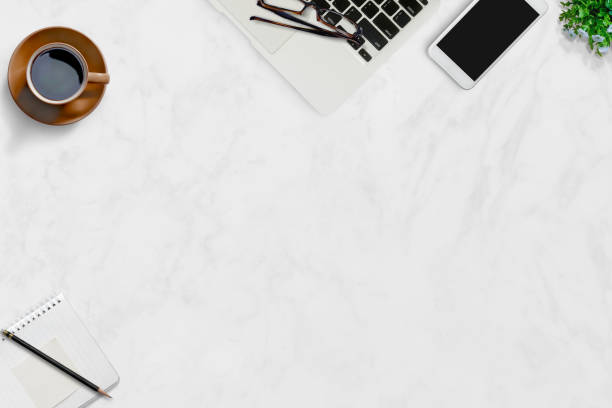 istock White marble office desk table with laptop and supplies. 833056184