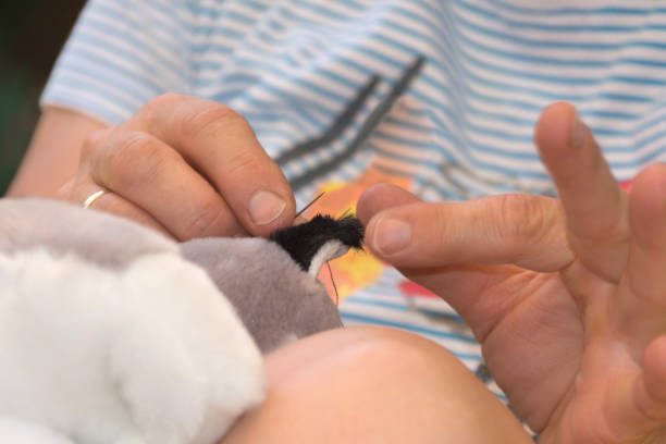 istock Woman sewing on a fabric animal with needle and thread 833057908