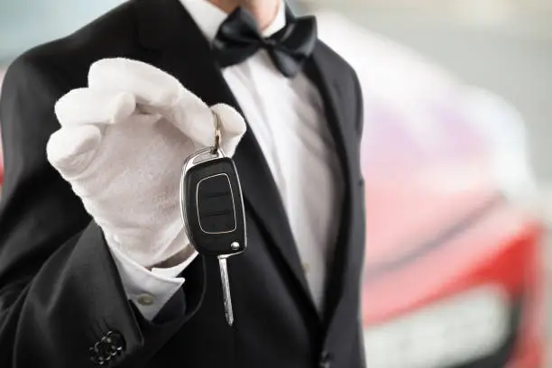 Close-up Of A Valet Boy Holding A Car Key Outside The Car