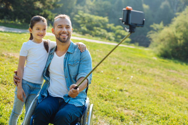 istock Happy father with disabilities taking a selfie with daughter 833072472