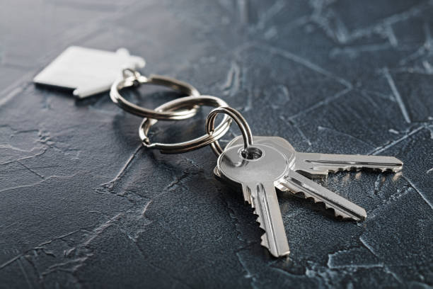 istock estate concept with key, keychain with house symbol, stone background 833075788