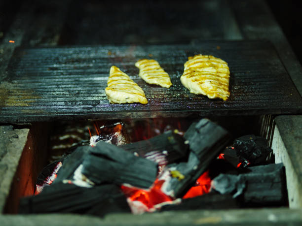 istock Grilled chicken on B-B-Q. Fried meat on a grid blurred background. Meat with firewood. Copy space. Outdoors concept. 833076526