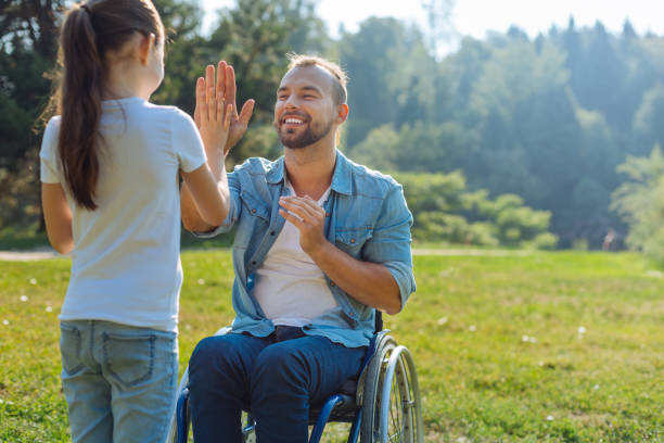 istock Little daughter giving her disabled father a high five 833076724