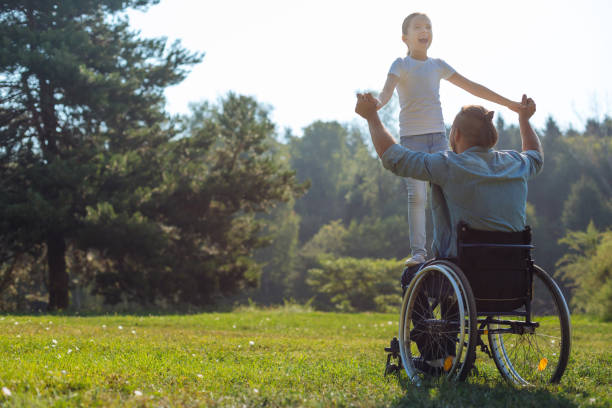 istock Mobility-impaired father holding his daughter on lap 833077396