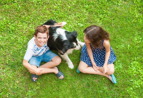 istock Children sitting on grass with their dog 833092154