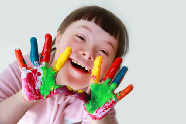 istock Cute little down syndrome girl with painted hands. 833107090