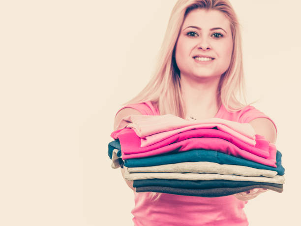 istock Woman holding pile of folded clothes 833135420