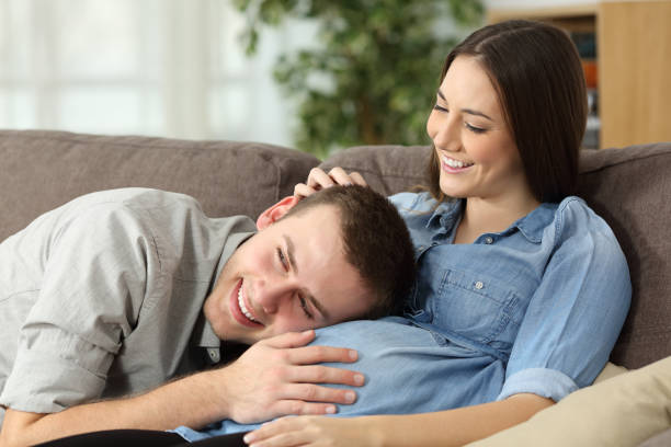 istock Father hearing his son kicking inside mother belly 833135434