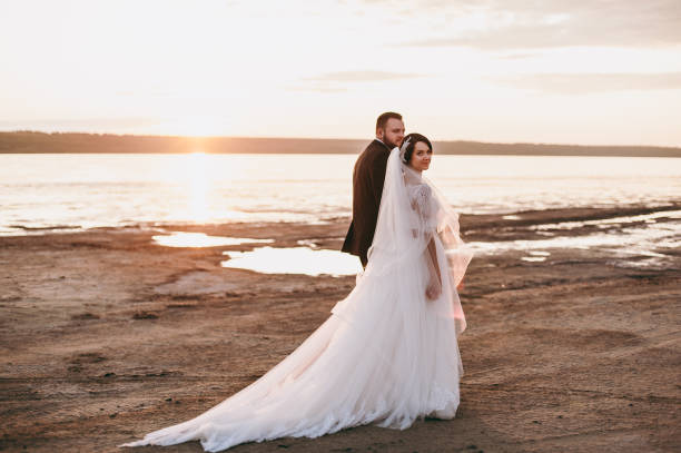 istock Groom and bride on a walk outdoors near the water 833137344