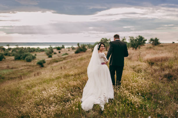 istock Groom and bride on a walk outdoors near the water 833137538