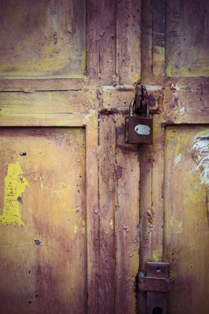 istock Weathered padlock and door with peeling paint 833137900