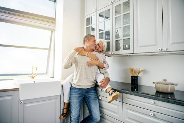 istock Laughing senior couple sharing a romantic moment in their kitchen 833137940