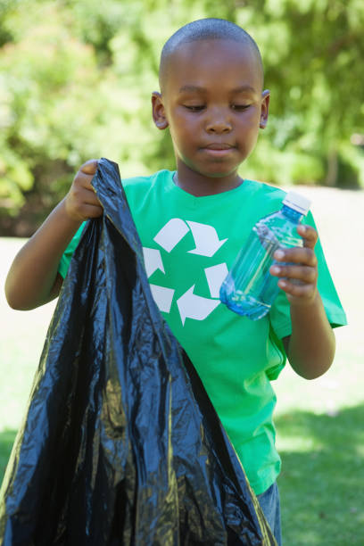 istock Little boy in recycling tshirt picking up trash 833143662