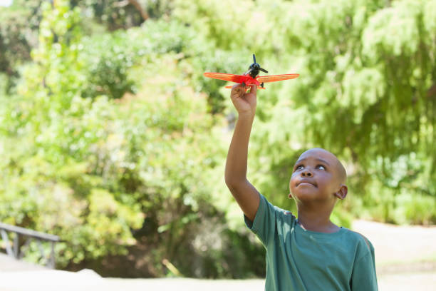 Happy little boy flying toy airplane