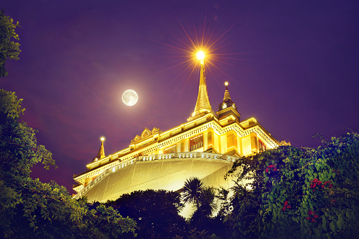 Full moon with cloud at the Golden Mount at Wat Sraket Rajavaravihara temple, Travel Landmark of Bangkok, Thailand