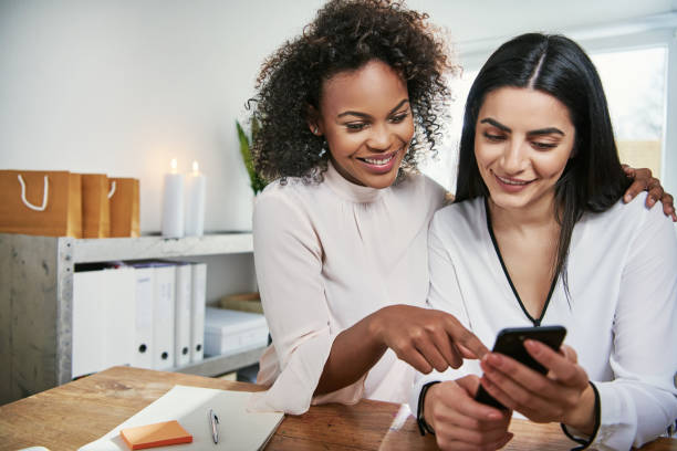 istock Two young businesswomen checking a mobile 833159774
