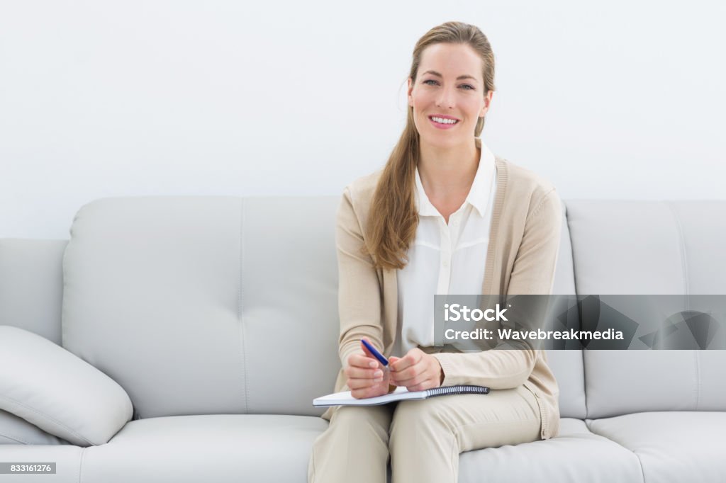 笑みを浮かべて女性心理学者のソファの上に座って - 精神保健専門家のロイヤリティフリーストックフォト