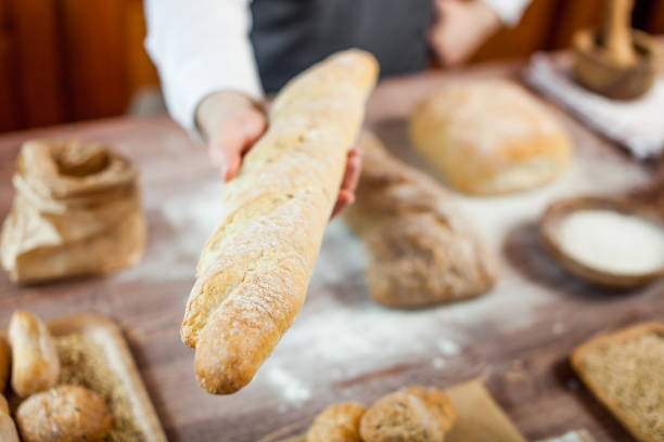 istock Baker man holding a beautiful fresh bread 833164966