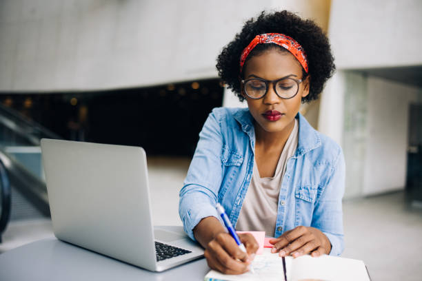 istock Focused young African female entrepreneur writing down business notes 833170452