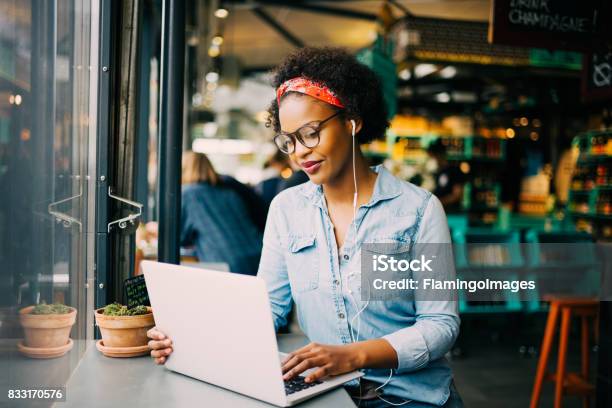 Giovane Donna Africana Concentrata Che Lavora Online In Un Bar - Fotografie stock e altre immagini di Caffetteria