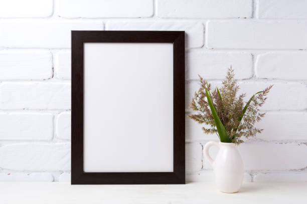 istock Black brown  frame mockup with grass and green leaves in pitcher vase 833170894