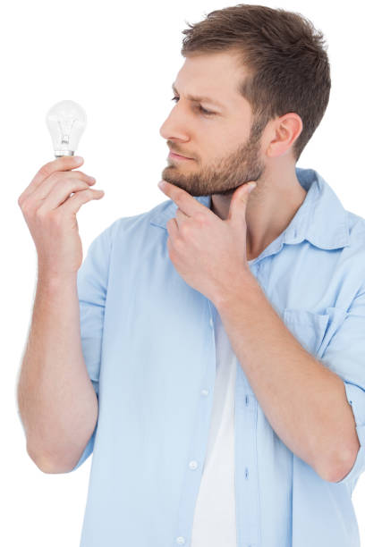 istock Sceptical model holding a bulb and looking at it 833175250
