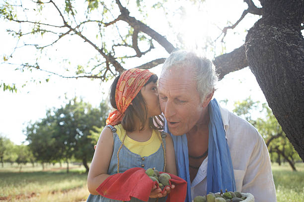 ragazza bisbigliato in grandfathers orecchio - whispering grandparent child grandfather foto e immagini stock